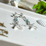 Edle „Ocean Star“ Ohrringe aus 925 Sterling Silber mit Seestern-Anhängern (18 × 17 mm), verziert mit einer aquablauen Apatitperle und funkelndem Zirkonia. Länge getragen: 45 mm. Maritime Schmuckstücke, die das Funkeln des Meeres einfangen – elegant, hochwertig und ein ideales Geschenk für Meeresliebhaber und Sommerträume.