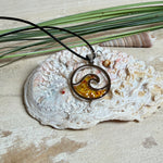 “Runder Wellenanhänger aus Edelstahl mit Bernstein-Harz-Inlay, Jaspisperle & facettiertem Bergkristall an schwarzer Lederkette (45 cm + 5 cm).”