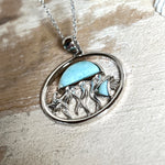 „Sealife“ – runder Anhänger aus rhodiniertem 925 Sterling Silber mit seltenem Larimar und funkelndem Topas. Das maritime Design zeigt eine Qualle, einen Fisch und einen Seestern. Anhängergröße ca. 32 × 26 mm, inklusive 45 cm langer Silberkette (1 mm Stärke). Symbol für die Schönheit und Vielfalt des Ozeans – jedes Stück ein Unikat durch das natürliche Farbspiel des Larimars.