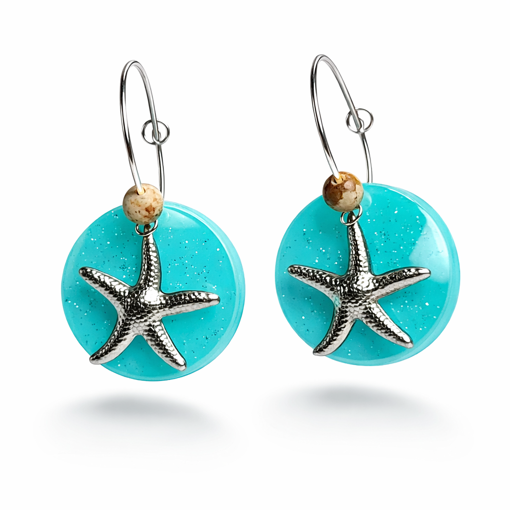 Handgefertigte Creolen-Ohrringe mit türkisblauer Resin-Scheibe, Glitzereffekt, silbernem Seestern-Charm und Jaspis-Natursteinperle. 925 Silber Creole, Gesamtlänge ca. 3,5 cm – Ocean-Feeling für jeden Tag.