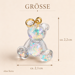 Größenbild SCHIMMERBÄR – handgefertigter Bärchen Anhänger aus klarem Resin mit irisierenden Flakes, goldfarbener Edelstahlschlaufe, ca. 2,2 x 2,1 cm, ohne Kette, glitzernder Mini-Charm als Unikat.