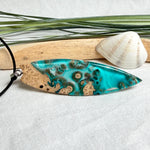 Surfboard Anhänger aus braunem Maserholz und türkisem Epoxidharz in Lagunenoptik an schwarzer Lederkette, maritimer Holz Harz Naturschmuck unisex