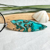 Surfboard Anhänger aus braunem Maserholz und türkisem Epoxidharz in Lagunenoptik an schwarzer Lederkette, maritimer Holz Harz Naturschmuck unisex