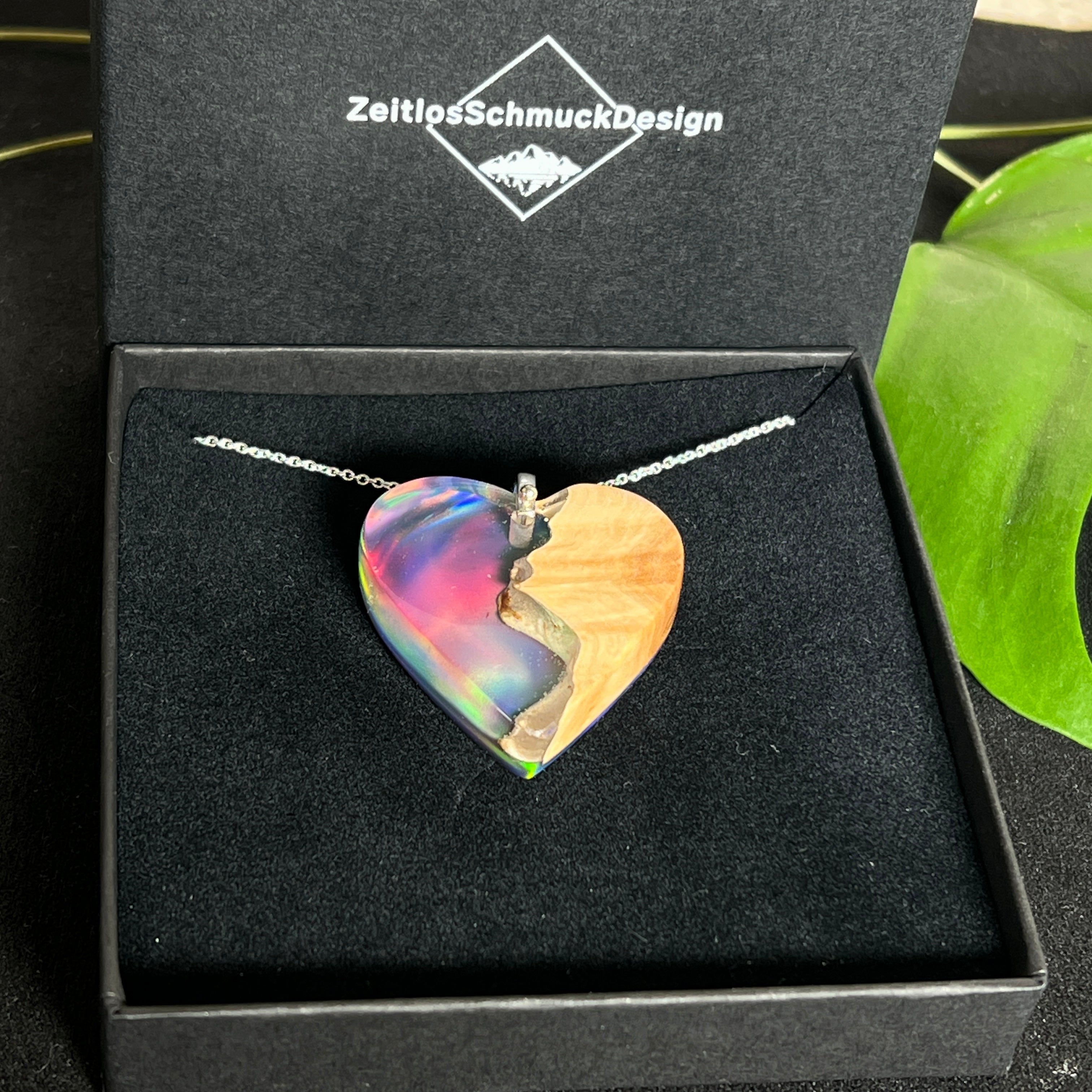 Handgefertigter Herzanhänger aus Maserholz und schimmerndem Opalharz, inspiriert von den Farben der Aurora Borealis. Das Holz zeigt eine feine Maserung, das Harz leuchtet in Rosa-, Blau- und Violetttönen. Mit zarter 925 Silber-Ankerkette (1 mm stark, 45 cm lang) und Silberöse. Ein edles Unikat in liebevoller Handarbeit gefertigt.