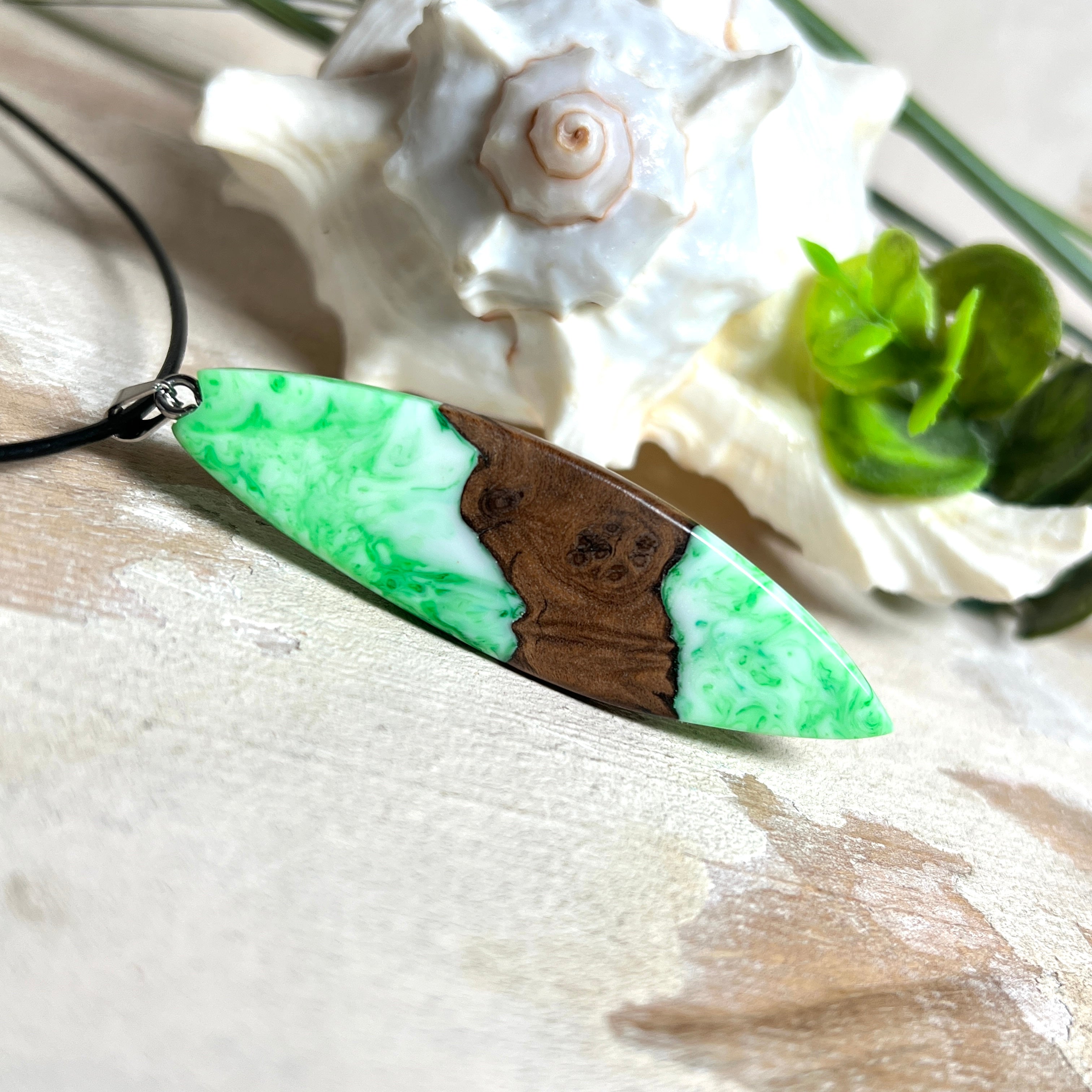 Anhänger aus Nussbaumholz und fluoreszierendem Epoxidharz in Grün-Weiß. Größe ca. 5,8 × 2 cm, Edelstahlöse, Lederkette 45+5 cm. Handgefertigtes Unikat.
