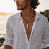 KI-Tragebild eines Mannes mit handgefertigter Halskette „Tropical Glow“ – Surfbrett Anhänger aus Rebholz und fluoreszierendem Epoxidharz in Grün, Orange und Türkis an schwarzem Lederband, maritimer Unisex Schmuck im Strandlook.