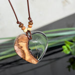 Herzanhänger „Pusteblumenzauber“ aus naturbelassenem Rebholz und klarem Epoxidharz mit schwebenden Pusteblumensamen. Dunkelbraunes, verstellbares Lederband mit kleinen Holzperlen, Anhänger ca. 3,5 × 3,5 cm. Handgefertigtes Unikat von ZeitlosSchmuckDesign.