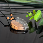 Handgefertigter Herzanhänger aus warm gemasertem Olivenholz und kristallklarem Epoxidharz mit schwebenden Pusteblumensamen. Schwarzes, verstellbares Lederband mit Schiebeknoten und naturfarbenen Holzperlen, Anhänger ca. 3,5 × 3,3 cm. Naturnaher Unikatschmuck von ZeitlosSchmuckDesign.