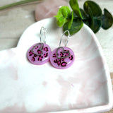 Handgemachte Leo-Creolen aus 925 Silber: Silber-Creolen 16 mm mit rosa Harz-Scheibe (2 cm) im Leoparden-Look und Edelstahl-Herzanhänger. Hängende Ohrringe in Animal-Print Stil, Gesamtlänge ca. 3,5 cm. Resin-Ohrringe für Alltag, Party oder Festival, femininer Statement-Schmuck in Rosa/Pink mit silberfarbenen Metallteilen. Einzeln gegossen, jedes Paar ein Unikat; leichte Abweichungen im Muster, Farbspiel und kleine Luftbläschen sind möglich und typisch für Handarbeit.