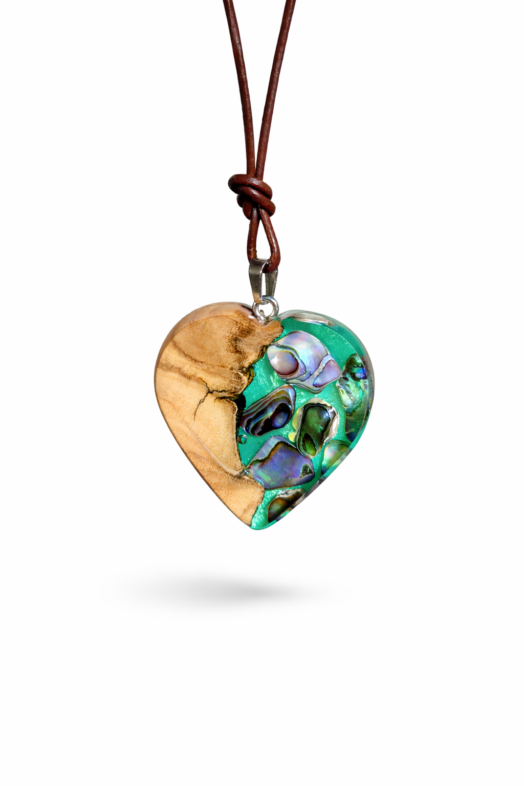 Herzförmiger Anhänger aus Olivenholz mit aquamarinfarbenem Harz und eingelegten Paua-Muschelstücken (Abalone), irisierender Blau-Grün-Schimmer. Der Anhänger hängt an einem braunen, verstellbaren Lederband mit Schiebeknoten; Aufhängung aus Edelstahl. Produktfoto vor maritimer Deko/Abalone-Schale.