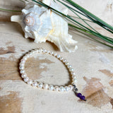 Handgefertigtes Armband „Sea Harmony“ mit schimmernden Süßwasserperlen (Ø ca. 6–7 mm), jede Perle ein Unikat. Auf elastischem Band gefädelt, mit einem filigranen Charmanhänger aus  Amethyst-Perlen, befestigt an einem robusten Edelstahl-Karabiner. Ein Schmuckstück voller Eleganz, maritimer Harmonie und symbolischer Tiefe – ideal als Geschenk oder als stilvolles Accessoire.