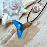 Handgefertigter Walflossen-Anhänger aus Olivenholz und Epoxidharz in Blau-Grün-Weiß, polierte Oberfläche, Edelstahl-Öse. Schwarze Lederkette 45 cm mit Edelstahl-Karabinerverschluss und 5 cm Edelstahl-Verlängerung. Anhängergröße ca. 2,5 × 3,2 cm, maritime Produktfotografie.