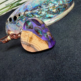 Handgemachter Herzanhänger aus Eibenholz mit lila Harz und Paua-Muschel-Inlay an braunem, verstellbarem Lederband.