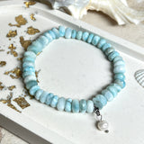 Handgefertigtes Armband aus seltenem Larimar mit facettierten, türkis-blauen Edelsteinperlen (Ø ca. 6–7 mm), elastischem Band und einem zarten Süßwasserperlen-Charm an Edelstahlkarabiner. Der wertvolle Larimar, auch „Stein des Atlantis“ genannt, gilt als Edelstein der Ruhe und Meeresverbundenheit.