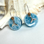 Handgefertigte Creolen-Ohrringe mit hellblauer Resin-Scheibe, zarter Wolkenmarmorierung, silbernem Walflosse-Charm und Jaspis-Natursteinperle. 925 Silber Creole, Gesamtlänge ca. 3,5 cm – Ocean-Feeling für jeden Tag.