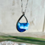„Lagunenlicht“ – Tropfenanhänger mit handmodellierter 3D-Welle und feinem Glitzereffekt. Klarer Harzlook in Blau/Türkis, gefasst in Silber-Legierung. Größe ca. 3,5 × 2 cm. Geliefert an einer versilberten Kette (ca. 56 cm). Hochglänzend , maritimer Unikatcharakter.