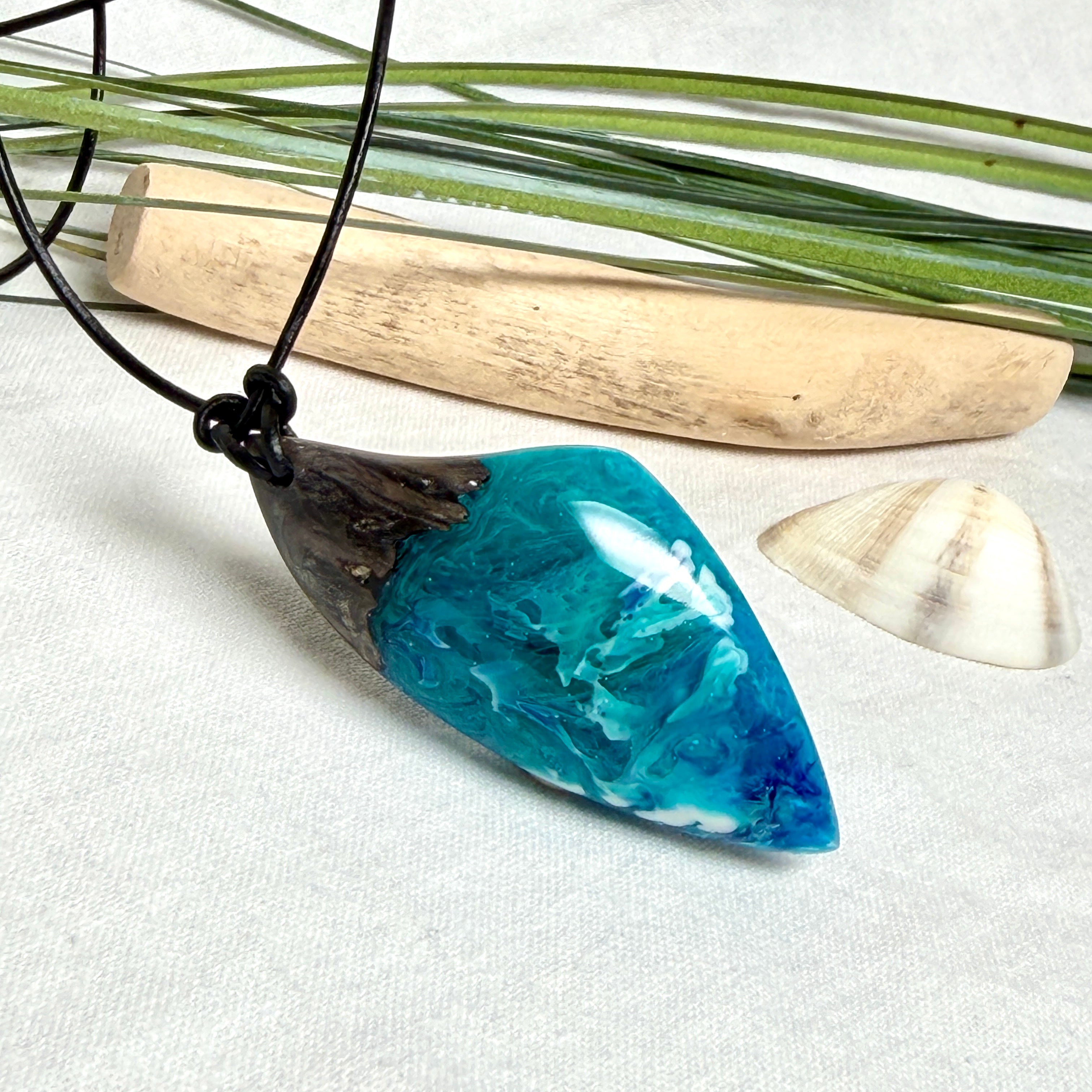 Anhänger aus dunklem Maserholz und Epoxidharz in Blau Türkis mit weißer Wellenstruktur am schwarzen Lederband, maritimer Holz Harz Naturschmuck unisex