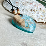 Handgefertigter Herzanhänger aus Maserholz und transparentem Ocean-Harz mit echtem Seestern und Muscheln. Die zarten Aqua-Farben erinnern an Meereswellen. Lederband verstellbar mit Holzperlen. Größe ca. 3,5 × 3,2 cm. Natürliches, maritimes Unikat von ZeitlosSchmuckDesign