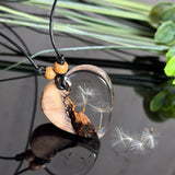 Handgefertigter herzförmiger Anhänger aus Olivenholz und klarem Epoxidharz mit echten schwebenden Pusteblumensamen, an verstellbarer schwarzer Lederkette mit Holzperlen, Unikat 