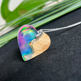 Handgefertigter Herzanhänger aus Maserholz und schimmerndem Opalharz, inspiriert von den Farben der Aurora Borealis. Das Holz zeigt eine feine Maserung, das Harz leuchtet in Rosa-, Blau- und Violetttönen. Mit zarter 925 Silber-Ankerkette (1 mm stark, 45 cm lang) und Silberöse. Ein edles Unikat in liebevoller Handarbeit gefertigt.