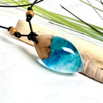 Holz-Harz-Anhänger aus Maserholz und Epoxidharz in Blau, Türkis und Weiß mit Wellenoptik am verstellbaren Lederband mit Holzperlen, handgemachter maritimer Naturschmuck