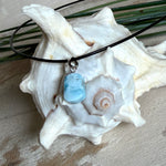 Larimar Freeform Anhänger mit rhodinierter Silberöse an schwarzer Lederkette. Der seltene, kostbare Larimar („Atlantisstein“) zeigt ein lebendiges Muster aus Türkis- und Weißtönen. Beidseitig tragbar, Steingröße ca. 2 x 1 cm, Lederkette 45 cm mit Edelstahl-Karabiner und 5 cm Verlängerung. Natürlicher, maritimer Unikatschmuck.