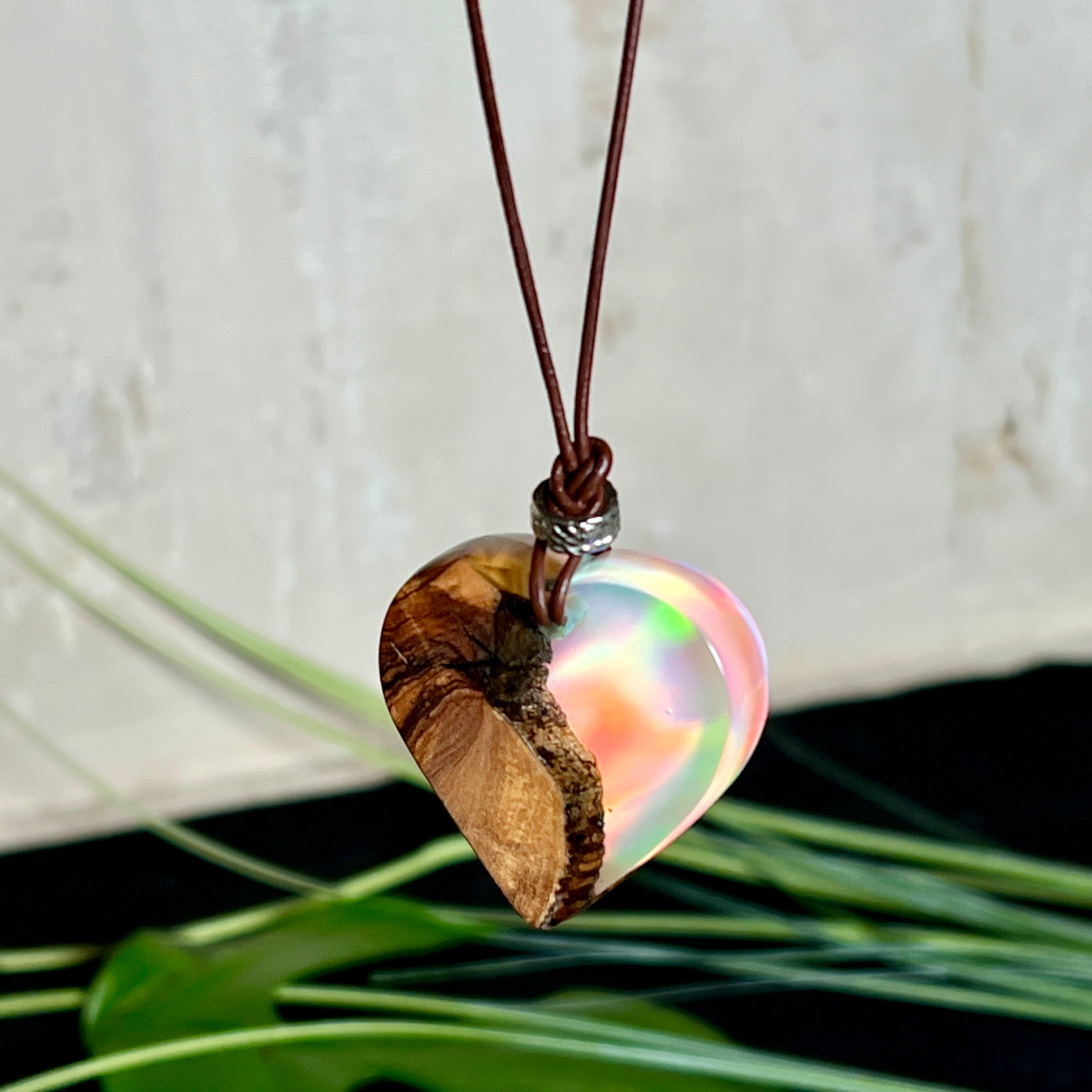 Handgefertigter Herzanhänger aus Olivenholz und schimmerndem Opalharz (Resin Colloidal Imitation Opal) – ein hochwertiges Harz mit feinen, lichtreflektierenden Partikeln, die an echte Opale erinnern. Je nach Licht schimmert der Anhänger in Regenbogenfarben. Mit braunem Lederband und silberfarbener Perle. Jedes Stück ein liebevoll gefertigtes Unikat.