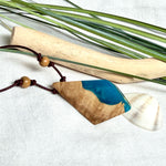 Anhänger aus hellem Goldfield Maserholz (Eukalyptus) und türkis metallischem Epoxidharz am braunen Lederband mit Holzperlen, maritimer Holz Harz Naturschmuck