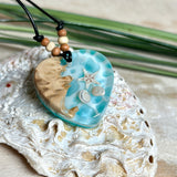 Handgefertigter Herzanhänger aus Maserholz und transparentem Ocean-Harz mit echtem Seestern und Muscheln. Die zarten Aqua-Farben erinnern an Meereswellen. Lederband verstellbar mit Holzperlen. Größe ca. 3,5 × 3,2 cm. Natürliches, maritimes Unikat von ZeitlosSchmuckDesign