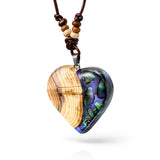 Handgemachter Herzanhänger aus Eibenholz mit lila Harz und Paua-Muschel-Inlay an braunem, verstellbarem Lederband.