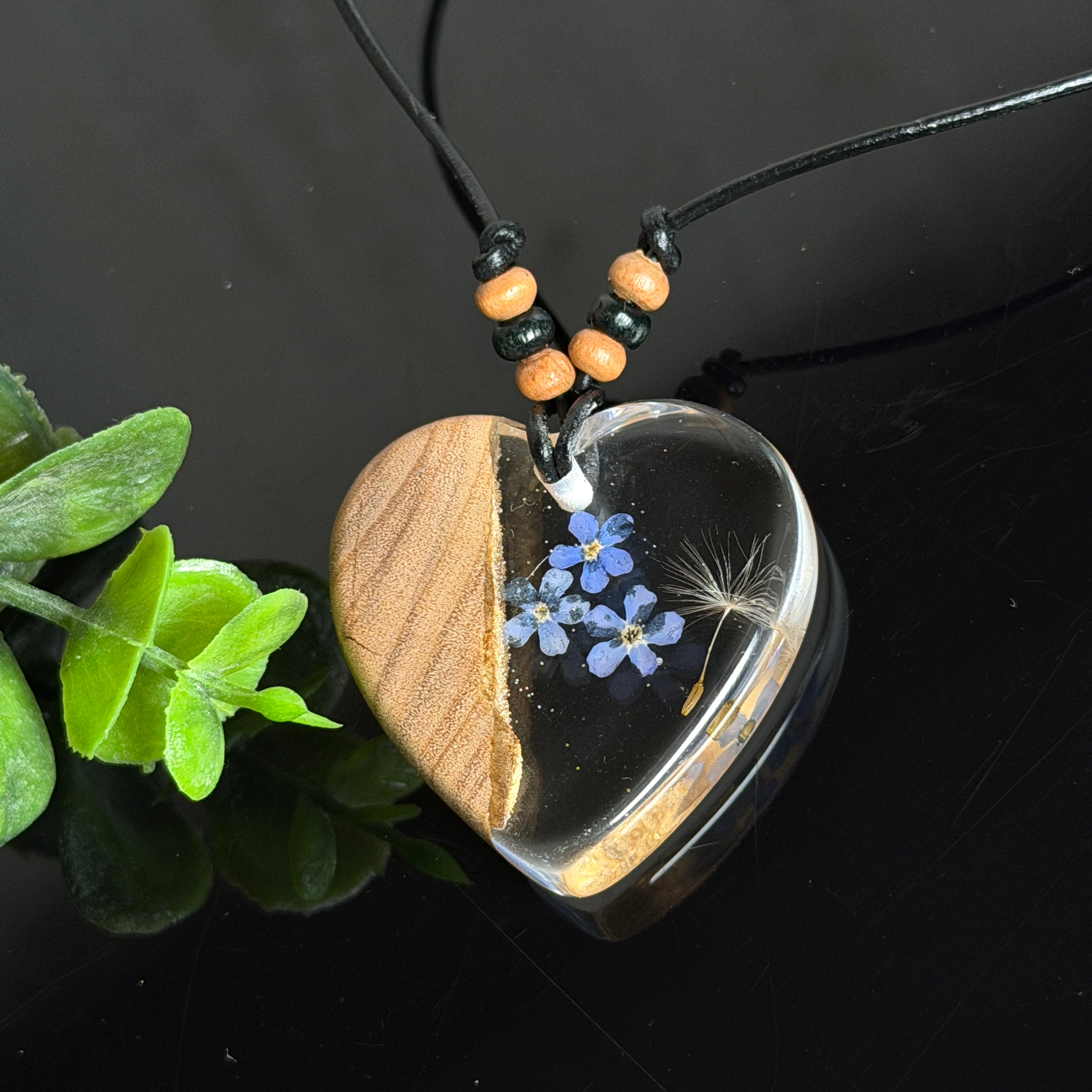 Handgefertigter herzförmiger Anhänger aus Olivenholz und Epoxidharz mit echten Vergissmeinnicht-Blüten und Pusteblumen-Samen, an verstellbarer schwarzer Lederkette mit Holzperlen, Unikat 