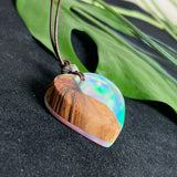 Handgefertigter Herzanhänger aus Olivenholz und schimmerndem Opalharz (Resin Colloidal Imitation Opal) – ein hochwertiges Harz mit feinen, lichtreflektierenden Partikeln, die an echte Opale erinnern. Je nach Licht schimmert der Anhänger in Regenbogenfarben. Mit braunem Lederband und silberfarbener Perle. Jedes Stück ein liebevoll gefertigtes Unikat.