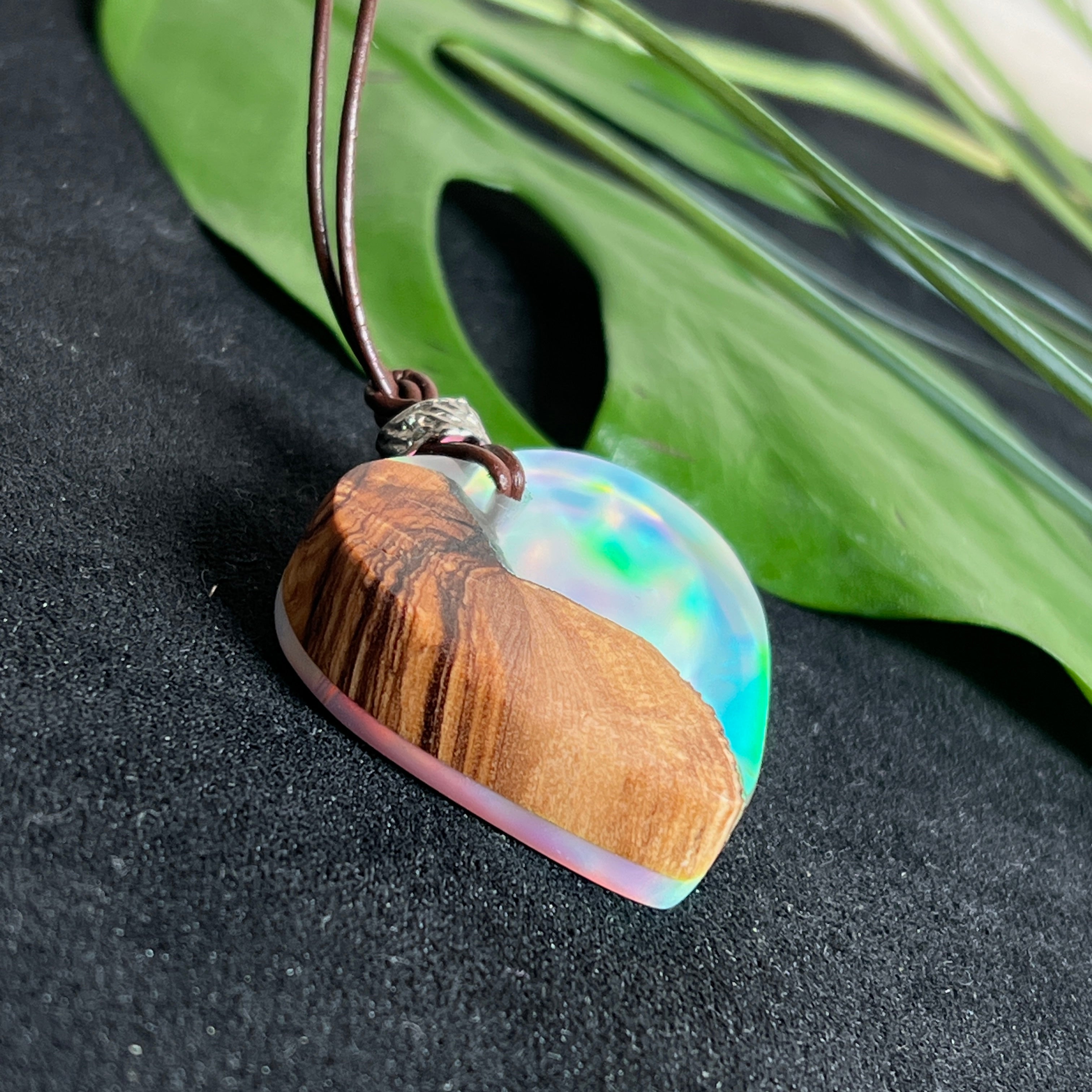 Handgefertigter Herzanhänger aus Olivenholz und schimmerndem Opalharz (Resin Colloidal Imitation Opal) – ein hochwertiges Harz mit feinen, lichtreflektierenden Partikeln, die an echte Opale erinnern. Je nach Licht schimmert der Anhänger in Regenbogenfarben. Mit braunem Lederband und silberfarbener Perle. Jedes Stück ein liebevoll gefertigtes Unikat.