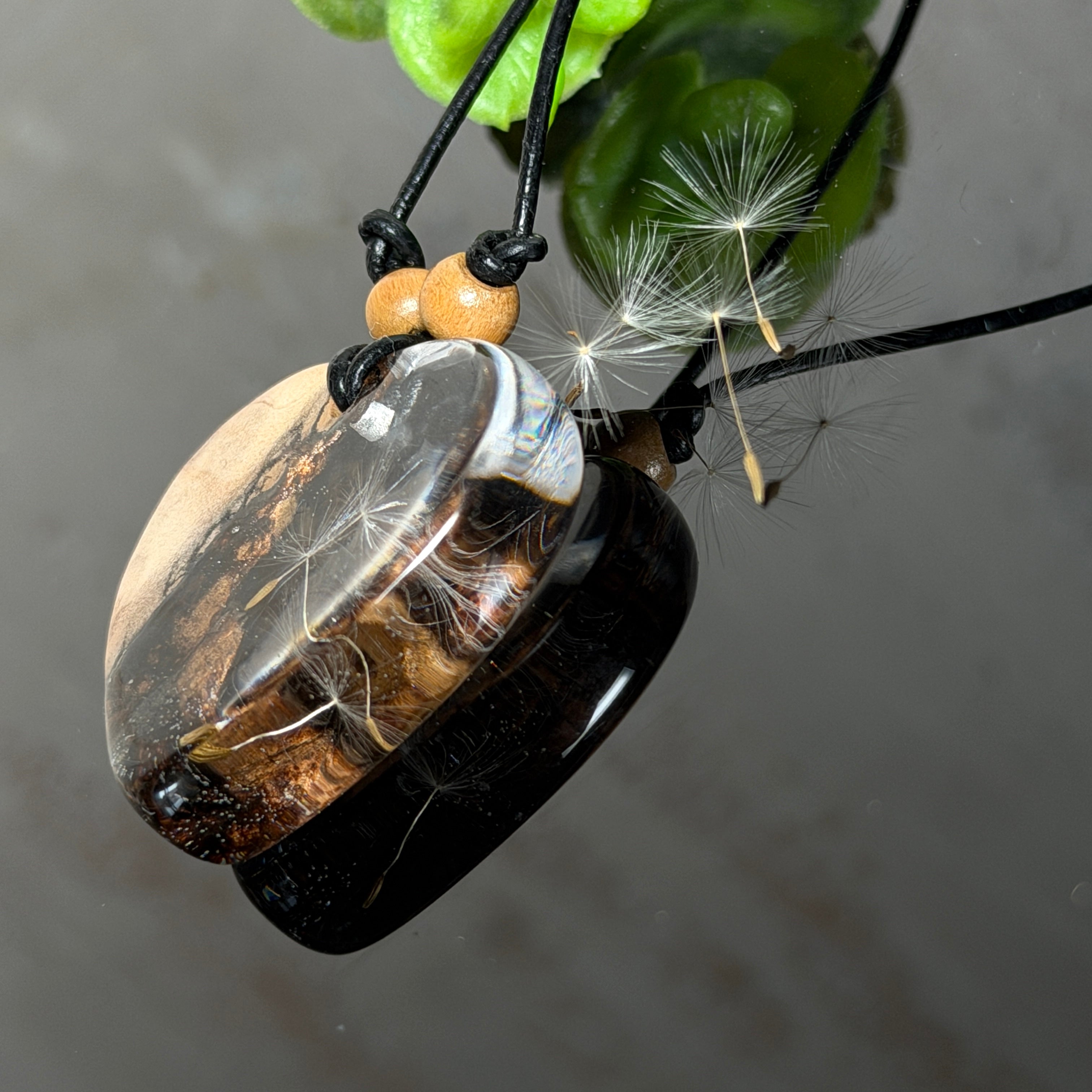 Handgefertigter herzförmiger Anhänger aus Olivenholz und klarem Epoxidharz mit echten schwebenden Pusteblumensamen, an verstellbarer schwarzer Lederkette mit Holzperlen, Unikat 