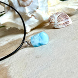 Larimar Freeform Anhänger mit rhodinierter Silberöse an schwarzer Lederkette. Der seltene, kostbare Larimar („Atlantisstein“) zeigt ein lebendiges Muster aus Türkis- und Weißtönen. Beidseitig tragbar, Steingröße ca. 2 x 1 cm, Lederkette 45 cm mit Edelstahl-Karabiner und 5 cm Verlängerung. Natürlicher, maritimer Unikatschmuck.