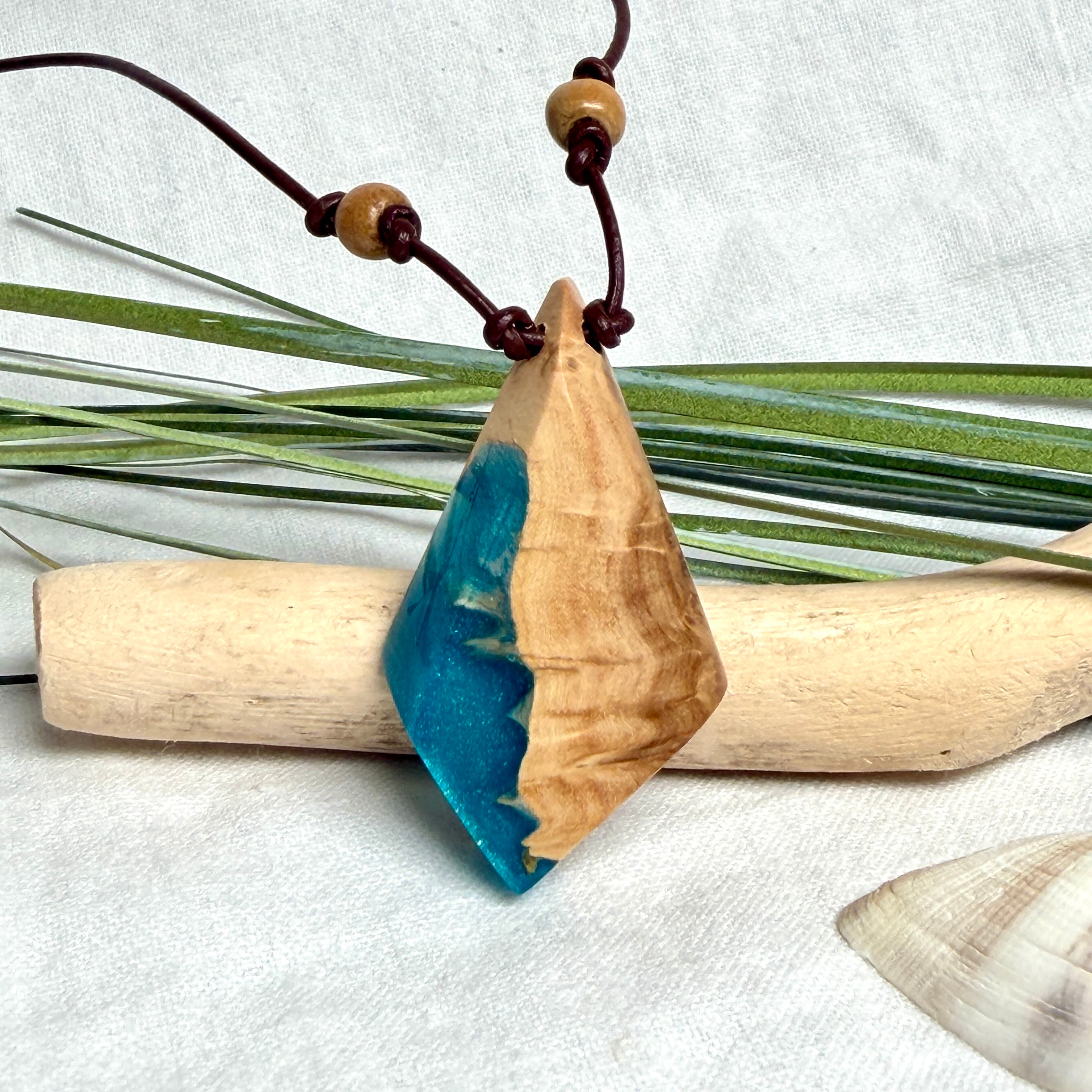 Anhänger aus hellem Goldfield Maserholz (Eukalyptus) und türkis metallischem Epoxidharz am braunen Lederband mit Holzperlen, maritimer Holz Harz Naturschmuck