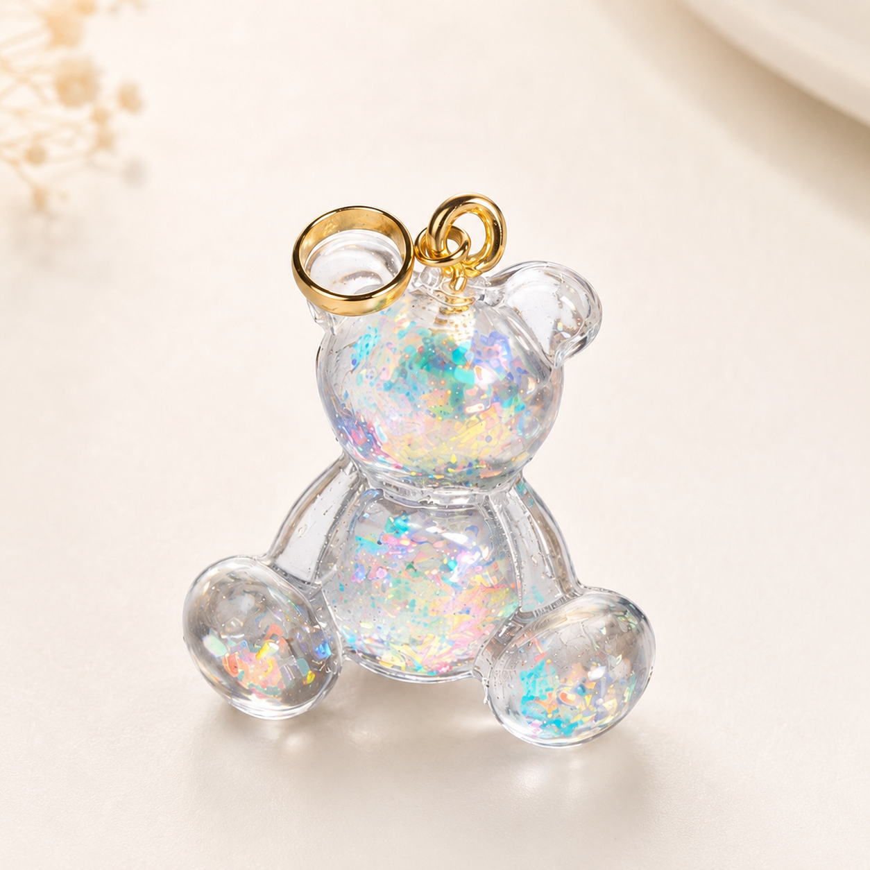 SCHIMMERBÄR Bärchen Anhänger aus klarem Resin mit irisierenden Flakes, goldfarbener Edelstahlschlaufe, handgefertigter Mini-Charm ohne Kette als glitzerndes Unikat.