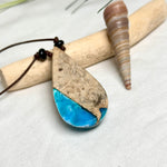 Holz-Harz-Anhänger aus Maserholz mit türkis-blauem Epoxidharz in Tropfenform am verstellbaren Lederband mit Onyxperlen, handgemachter maritimer Naturschmuck