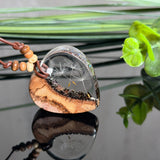 Herzanhänger „Pusteblumenzauber“ aus naturbelassenem Rebholz und klarem Epoxidharz mit schwebenden Pusteblumensamen. Dunkelbraunes, verstellbares Lederband mit kleinen Holzperlen, Anhänger ca. 3,5 × 3,5 cm. Handgefertigtes Unikat von ZeitlosSchmuckDesign.