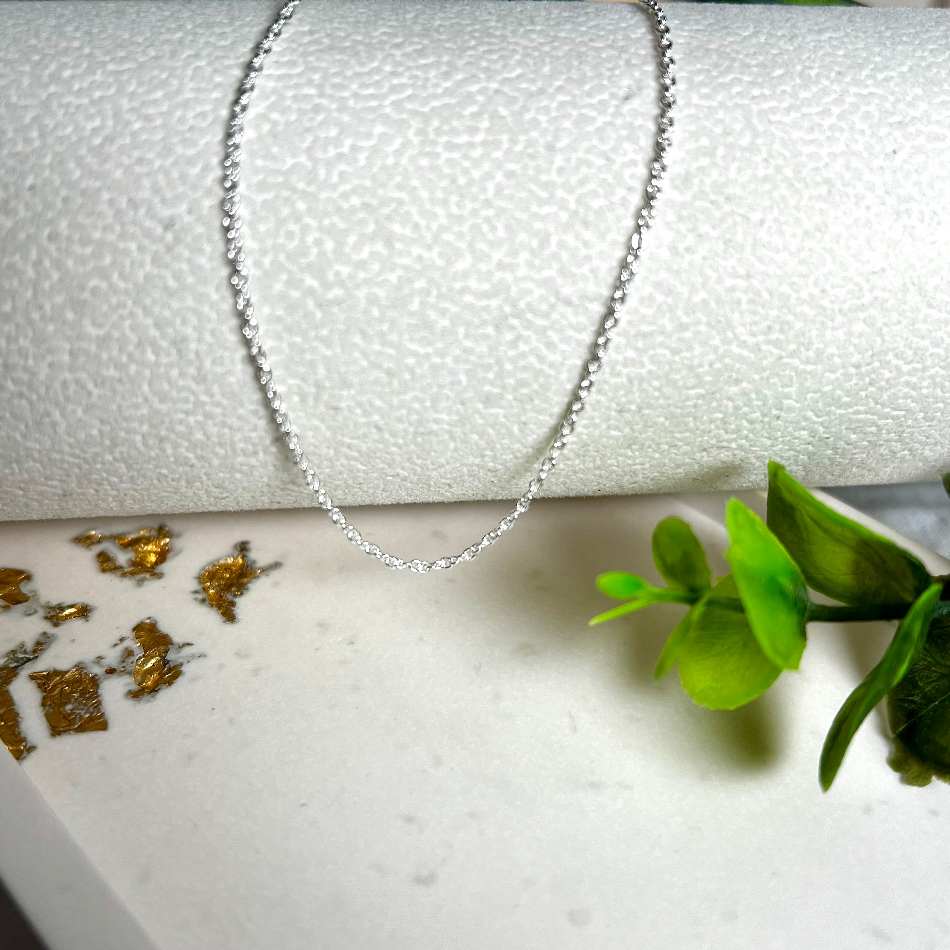 Zarte Ankerkette aus echtem 925 Silber mit klassischem Federring-Verschluss, 1 mm dick, 45 cm lang. Schlichtes, edles Design – ideal für Anhänger oder als feine Solokette. Stilvolle Schmuckfotografie mit natürlichem Hintergrund.