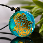 Schutzamulett Hamsa Licht – goldenes Hamsa-Hand-Motiv mit Auge auf türkis-grünem Epoxidharz Cabochon, ZeitlosSchmuckDesign