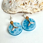 Handgefertigte Creolen-Ohrringe mit hellblauer Resin-Scheibe, zarter Wolkenmarmorierung, silbernem Walflosse-Charm und Jaspis-Natursteinperle. 925 Silber Creole, Gesamtlänge ca. 3,5 cm – Ocean-Feeling für jeden Tag.