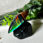 Der handgefertigte Anhänger „Celestial Flame“ kombiniert warmes Olivenholz mit glasklarem Harz und irisierendem Opal. Das einzigartige Farbspiel erinnert an Polarlichter und verleiht dem Schmuckstück eine mystische Tiefe. Die Oberfläche ist glatt poliert, der Anhänger wird an einem verstellbaren Lederband getragen – ein ausdrucksstarkes Unikat für alle, die Naturmaterialien und kreative Farben lieben.
