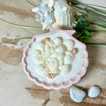 Handgefertigte Kerze „Meeresträume“ in einer Jesmonite-Schale (ca. 11 cm). Gefüllt mit nachhaltigem Sojawachs, verziert mit echten Muscheln, handgegossenen Wachsmuscheln und Seepferdchen. Feiner Glitzer sorgt für funkelnde Lichteffekte im Kerzenschein. Maritime Deko – edel, einzigartig & perfekt als Geschenk.