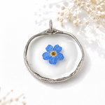 Vergissmeinnicht Anhänger handgefertigt, echte blaue Blume in transparentem Resin mit silberfarbener Fassung, einzigartiger Natur Schmuck mit symbolischer Bedeutung.