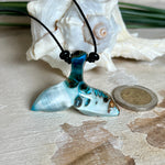 Handgefertigter Walflossen-Anhänger „Flossenklang“ aus Maserholz und türkis-blau-grau-weiß marmoriertem Epoxidharz an verstellbarem Lederband. Maritime Kette als Unikatschmuck für Meeresliebhaber und Wal-Fans, hochwertig poliert, präsentiert vor Muscheldeko und in Schmuckbox von ZeitlosSchmuckDesign.