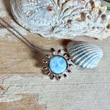 Feine Halskette aus rhodiniertem 925 Silber mit Sonnen-Anhänger und rundem Larimar-Cabochon, 10 mm. Der seltene, hellblaue Stein aus der Dominikanischen Republik erinnert an Meer und Himmel. Gesamtgröße des Anhängers ca. 20 x 19 mm, Ankerkette 45 cm, ca. 1 mm stark. Edler, maritimer Schmuck, geliefert in einer Geschenkbox.
