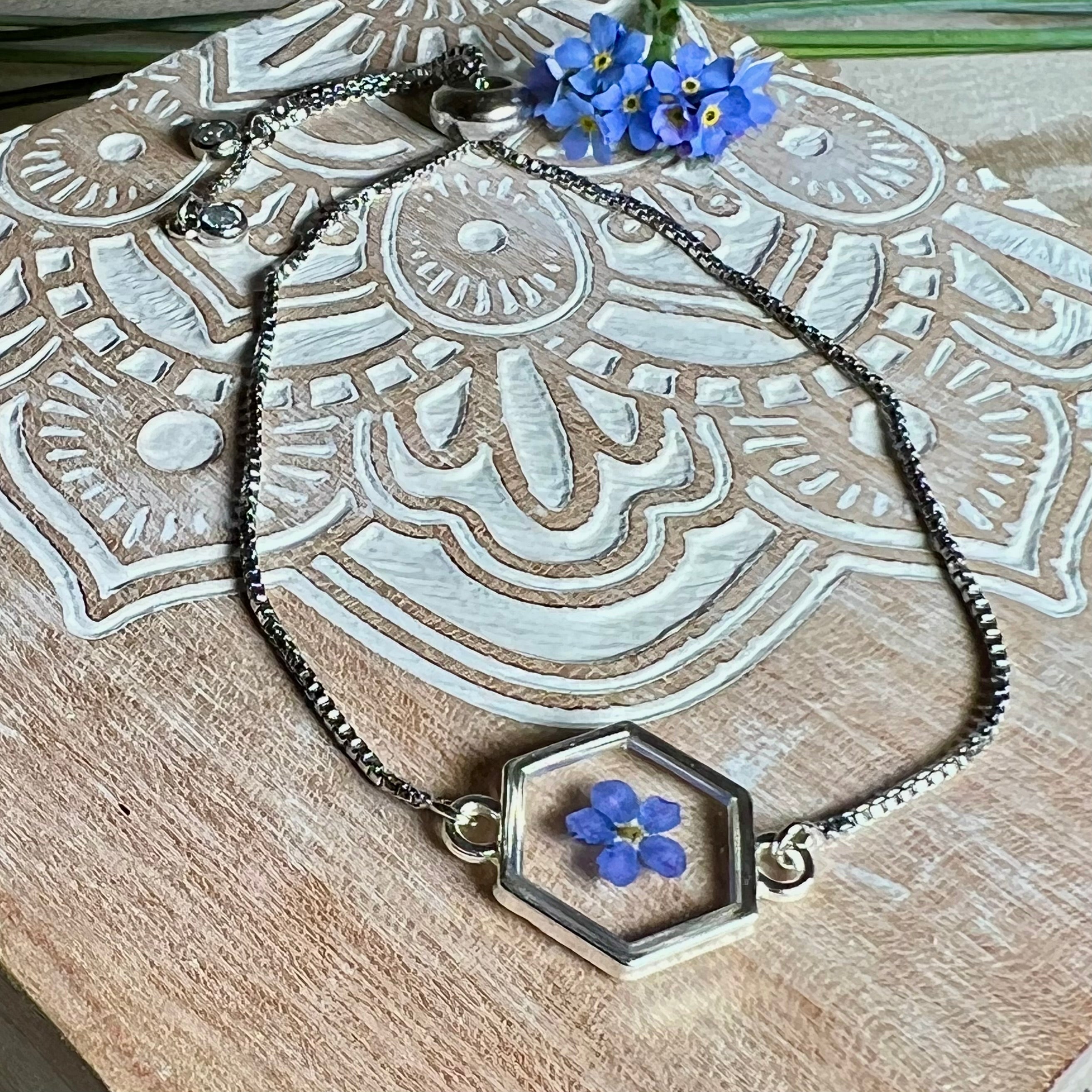 „Handgefertigtes Armband mit echter Vergissmeinnicht-Blume, eingebettet in klares Harz. Verstellbares Edelstahlarmband mit Schiebeverschluss und funkelnden Zirkonia-Endperlen. Symbolträchtiger Schmuck für Frauen – ideal als Geschenk zum Muttertag, Geburtstag oder zur Erinnerung an einen besonderen Menschen.“
