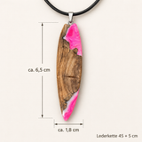 Größenbild des handgefertigten „Pink Glow“ Surfbrett Anhängers aus Olivenholz und fluoreszierendem Epoxidharz in Pink-Weiß, ca. 6,5 x 1,8 cm, schwarze Lederkette 45 + 5 cm, maritimer Unikat Schmuck mit UV-Schwarzlicht-Effekt.