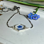 „Handgefertigtes Armband mit echter Vergissmeinnicht-Blume, eingebettet in klares Harz. Verstellbares Edelstahlarmband mit Schiebeverschluss und funkelnden Zirkonia-Endperlen. Symbolträchtiger Schmuck für Frauen – ideal als Geschenk zum Muttertag, Geburtstag oder zur Erinnerung an einen besonderen Menschen.“
